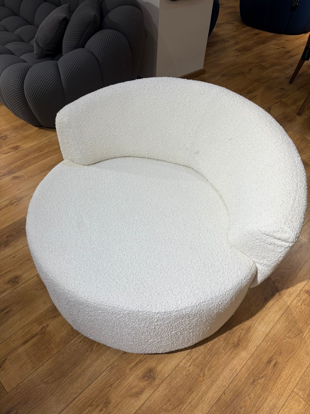 Bergère moderne blanche en tissu bouclette avec design arrondi et assise confortable pour salon contemporain.