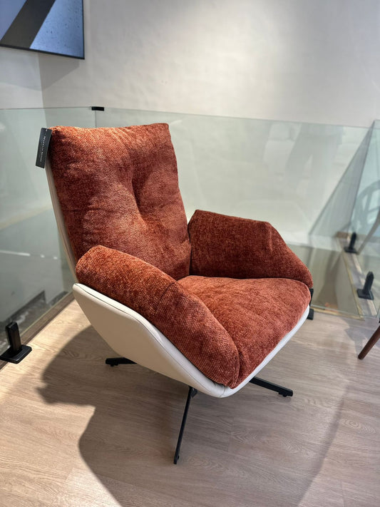 Fauteuil moderne avec dossier haut, coussins épais et base métallique stable pour un confort optimal.