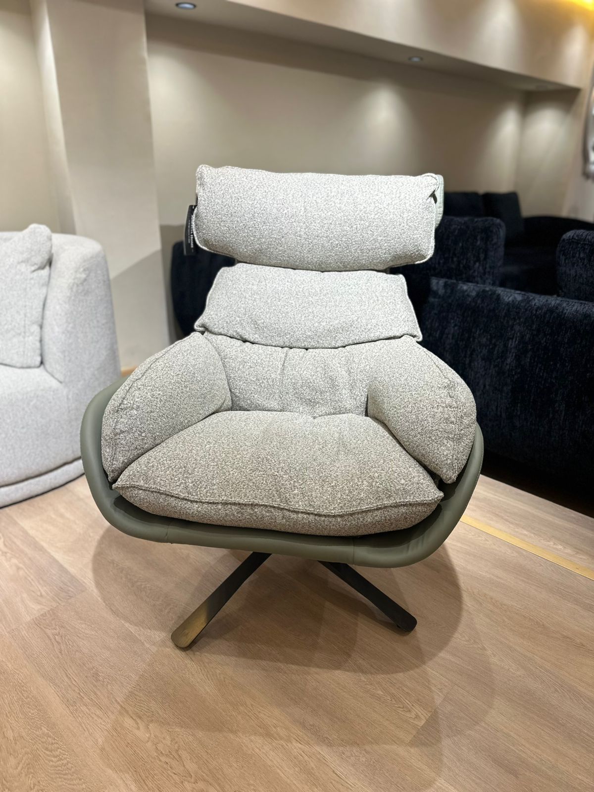 Fauteuil moderne avec dossier ergonomique, assise rembourrée et base pivotante en métal, offrant confort et style contemporain.