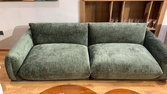 Canapé en velours chiné vert avec des accoudoirs larges et assise profonde.