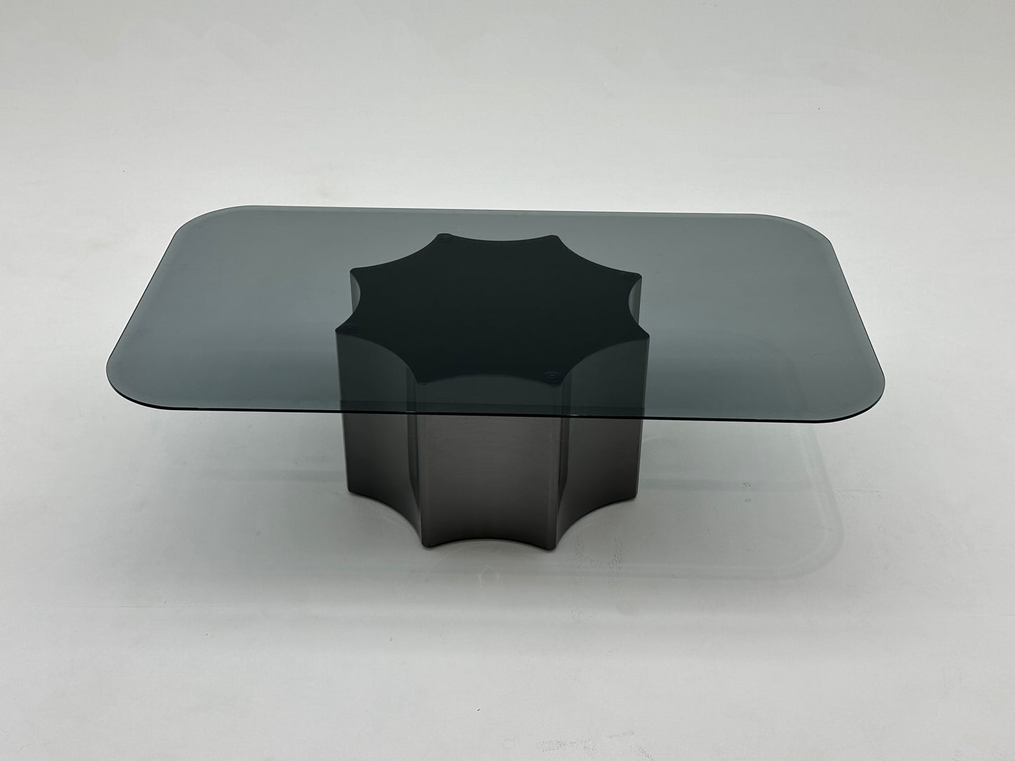Table basse moderne avec plateau en verre fumé et base en métal solide. Un design minimaliste qui combine élégance et robustesse.