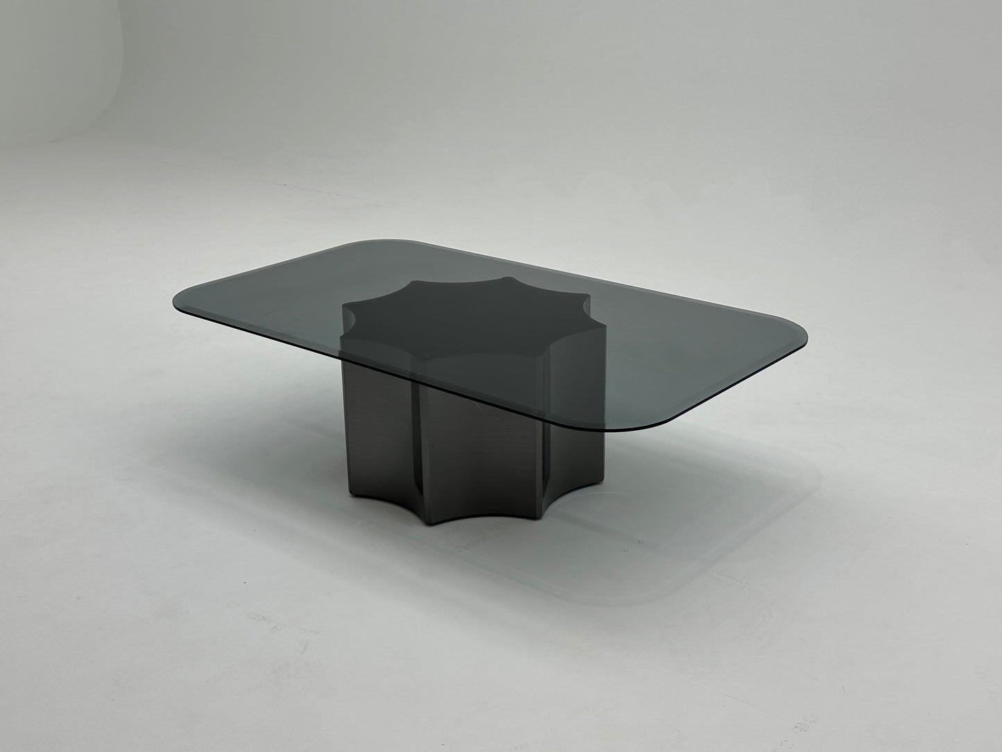 Table basse moderne avec plateau en verre fumé et base en métal solide. Un design minimaliste qui combine élégance et robustesse.