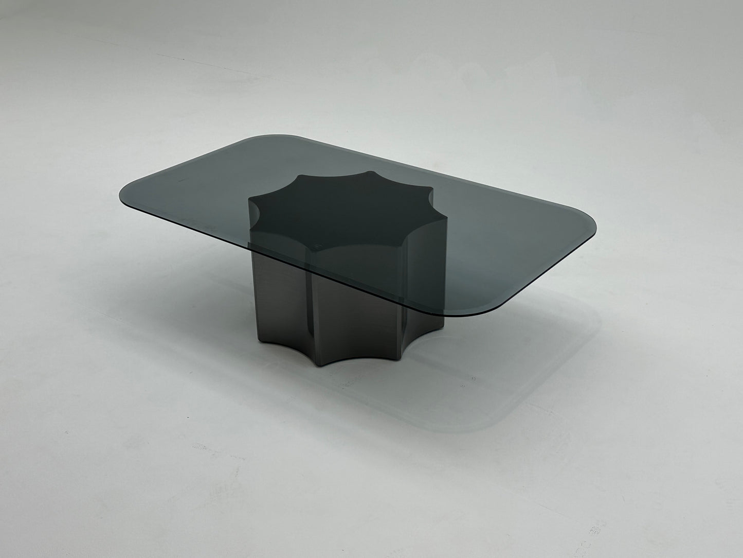 Table basse moderne avec plateau en verre fumé et base en métal solide. Un design minimaliste qui combine élégance et robustesse.