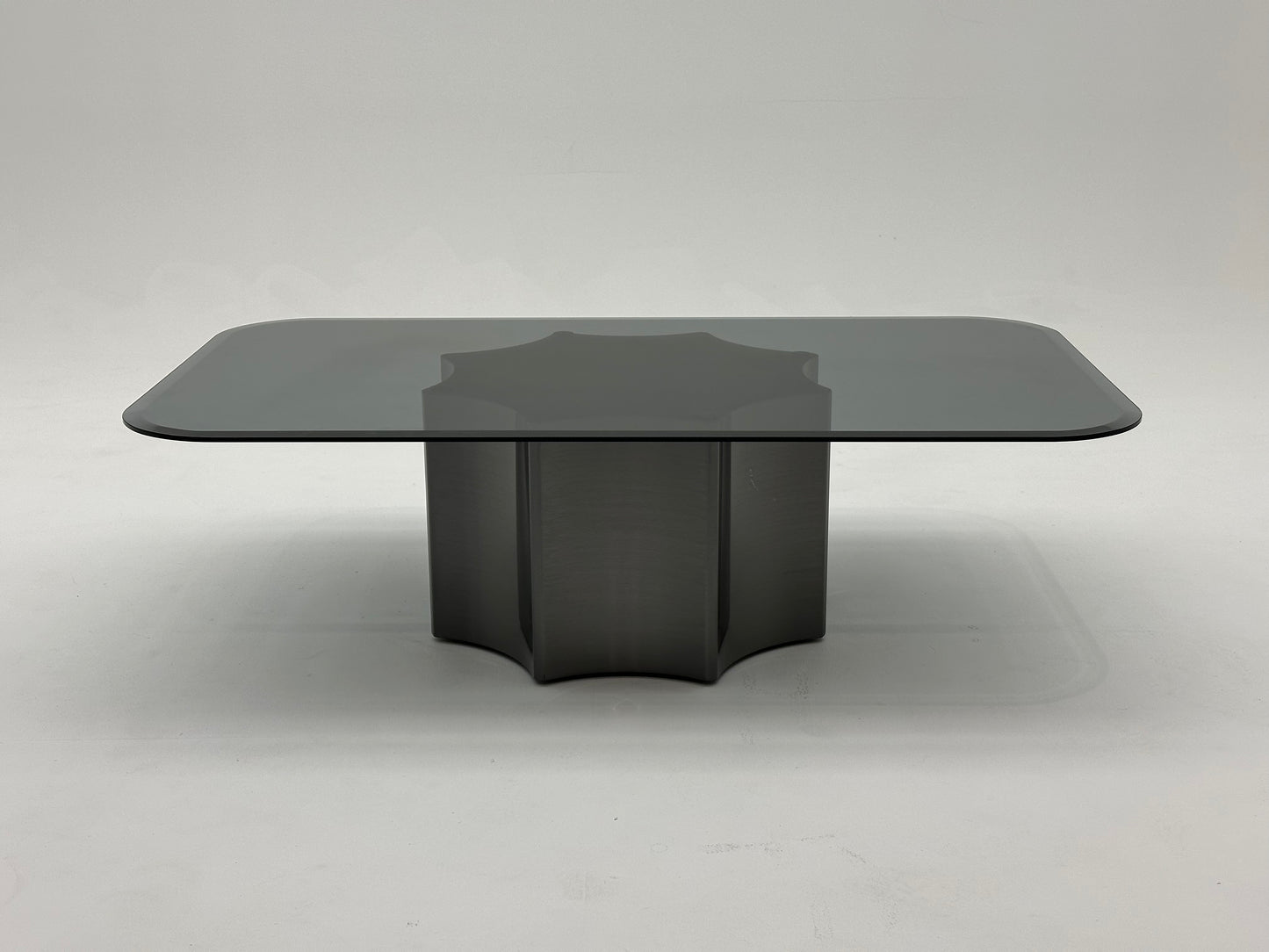 Table basse moderne avec plateau en verre fumé et base en métal solide. Un design minimaliste qui combine élégance et robustesse.
