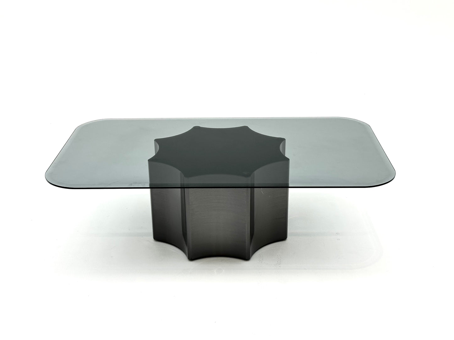 Table basse moderne avec plateau en verre fumé et base en métal solide. Un design minimaliste qui combine élégance et robustesse.