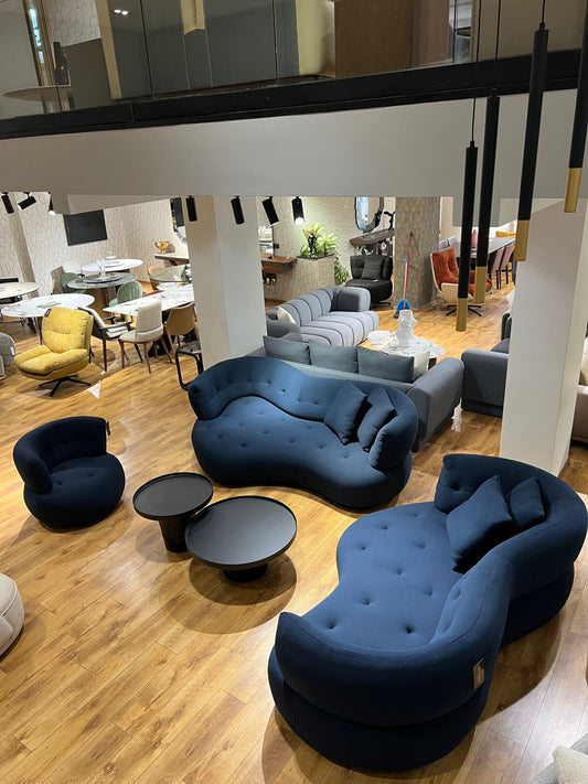 Salon design avec canapé aux courbes modernes et fauteuils assortis.