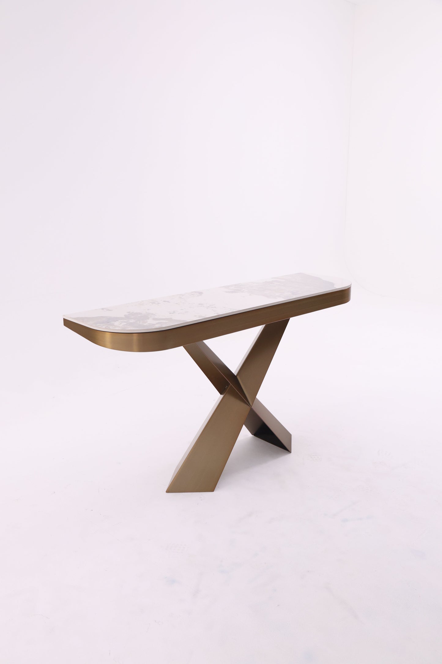Console moderne avec plateau en marbre et piètement croisé en métal traité, design élégant et géométrique.