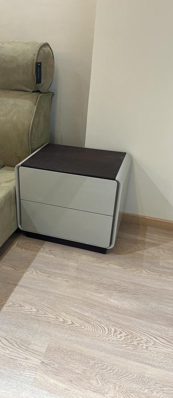 Table de chevet moderne avec deux tiroirs et plateau foncé effet bois.