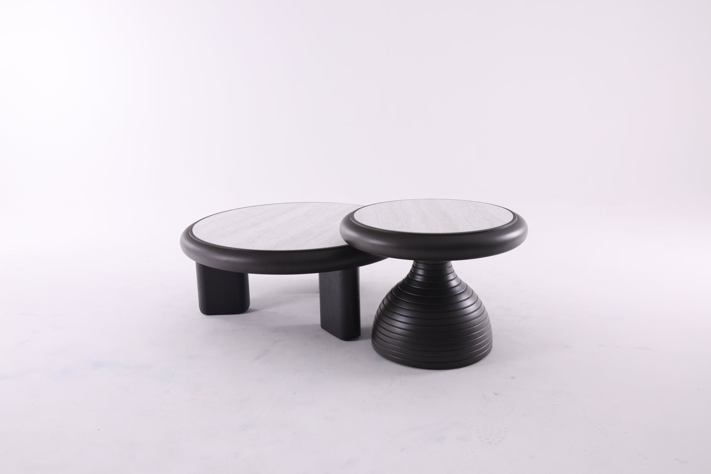 Deux tables basses rondes en bois de tailles différentes, au design chaleureux et aux finitions lisses, idéales pour un salon contemporain.