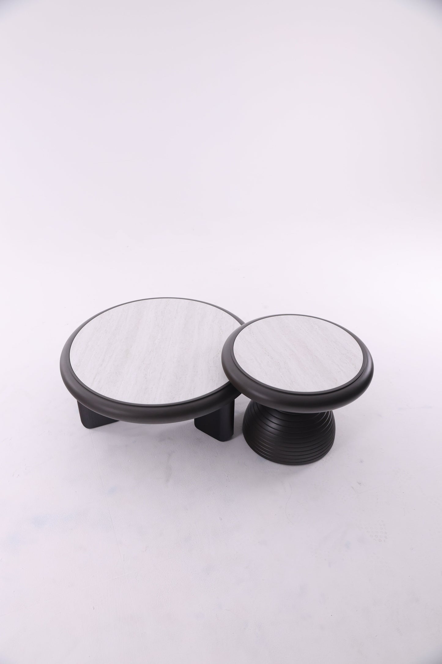 Deux tables basses rondes en bois de tailles différentes, au design chaleureux et aux finitions lisses, idéales pour un salon contemporain.