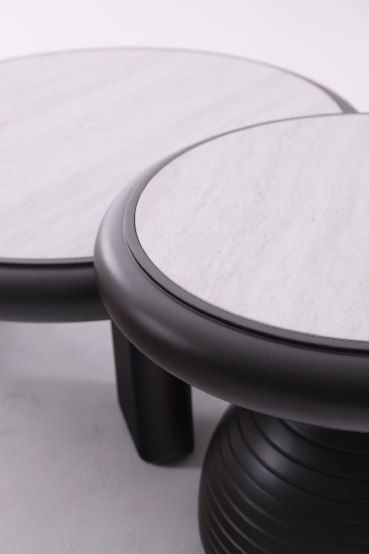 Deux tables basses rondes en bois de tailles différentes, au design chaleureux et aux finitions lisses, idéales pour un salon contemporain.