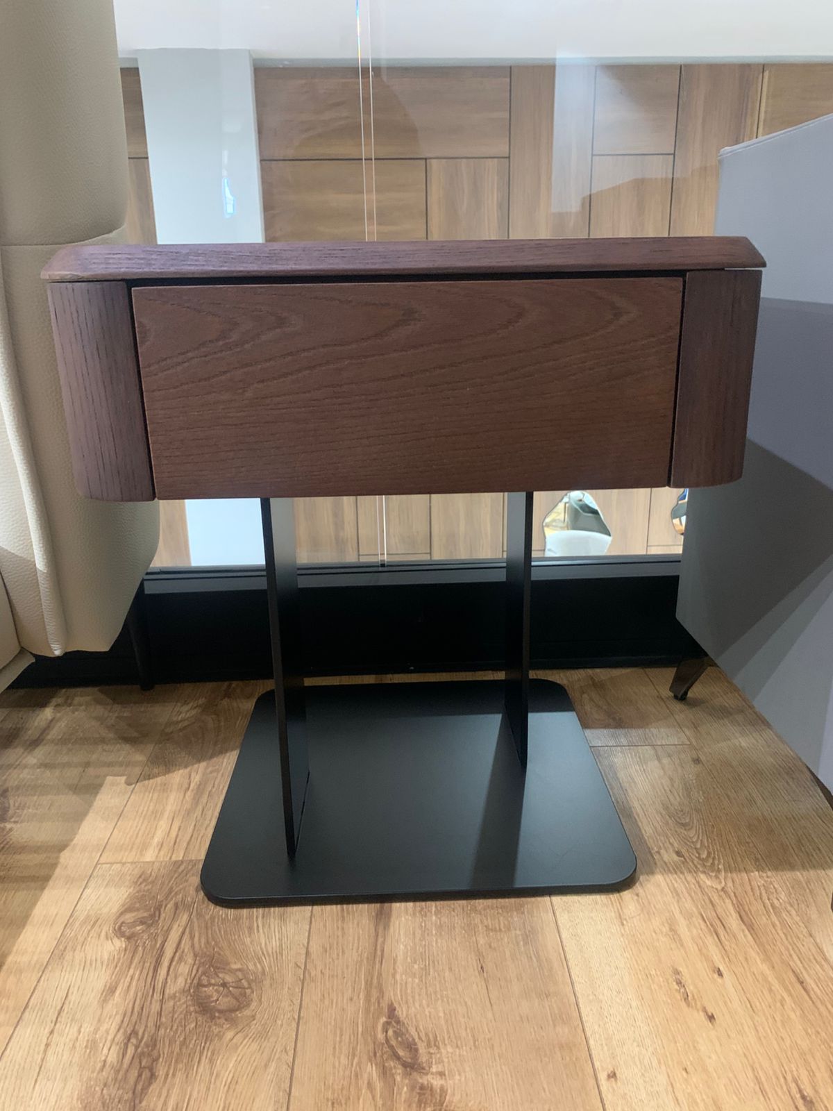 Table de chevet moderne en bois foncé avec tiroir et piètement central en métal noir, au design minimaliste et élégant.