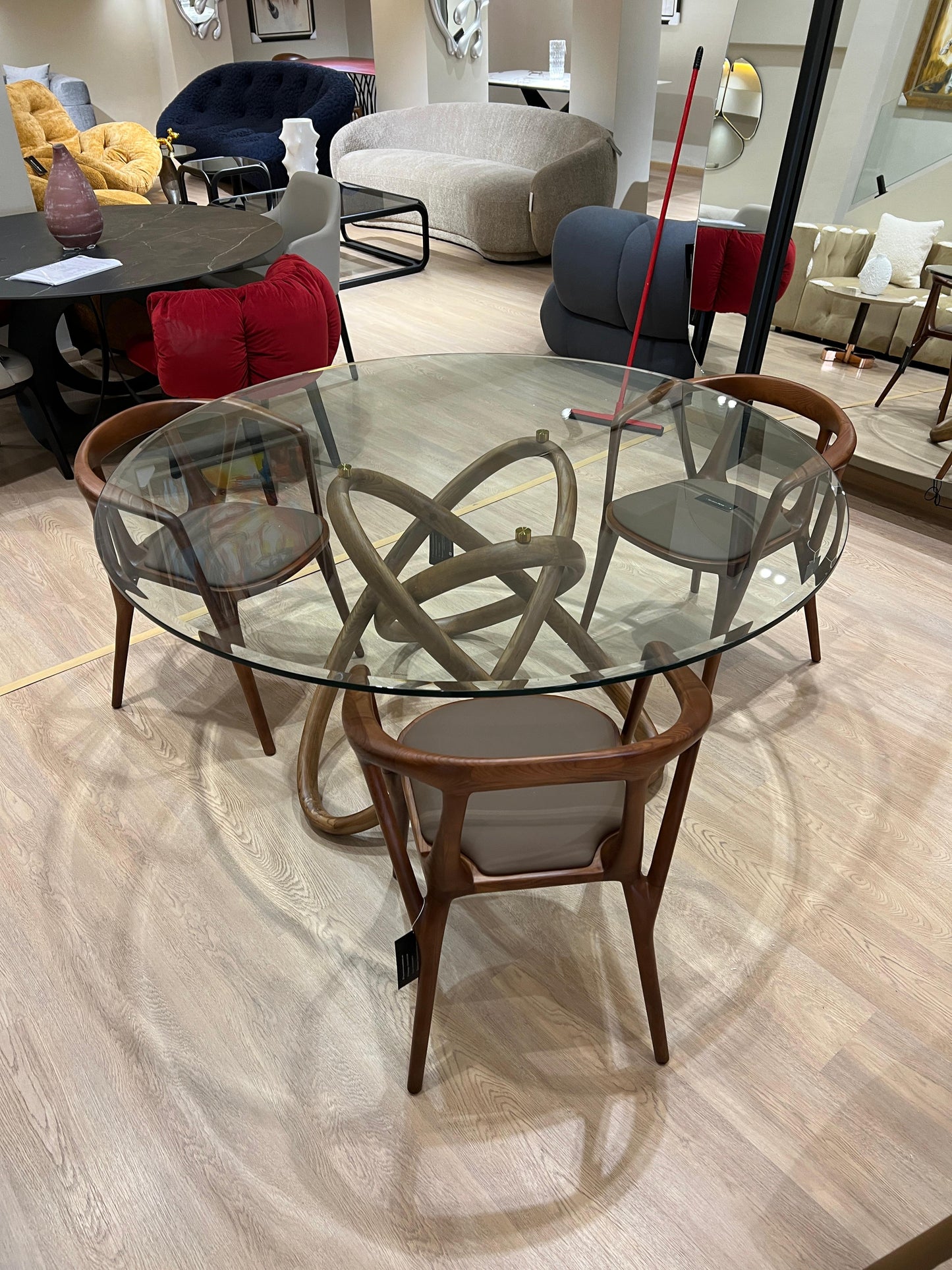 Table ronde design avec base en bois entrelacé et plateau en verre