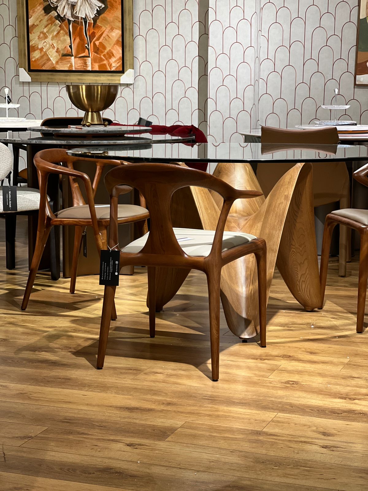 Table ronde design avec base en bois sculpté ondulé et plateau en verre