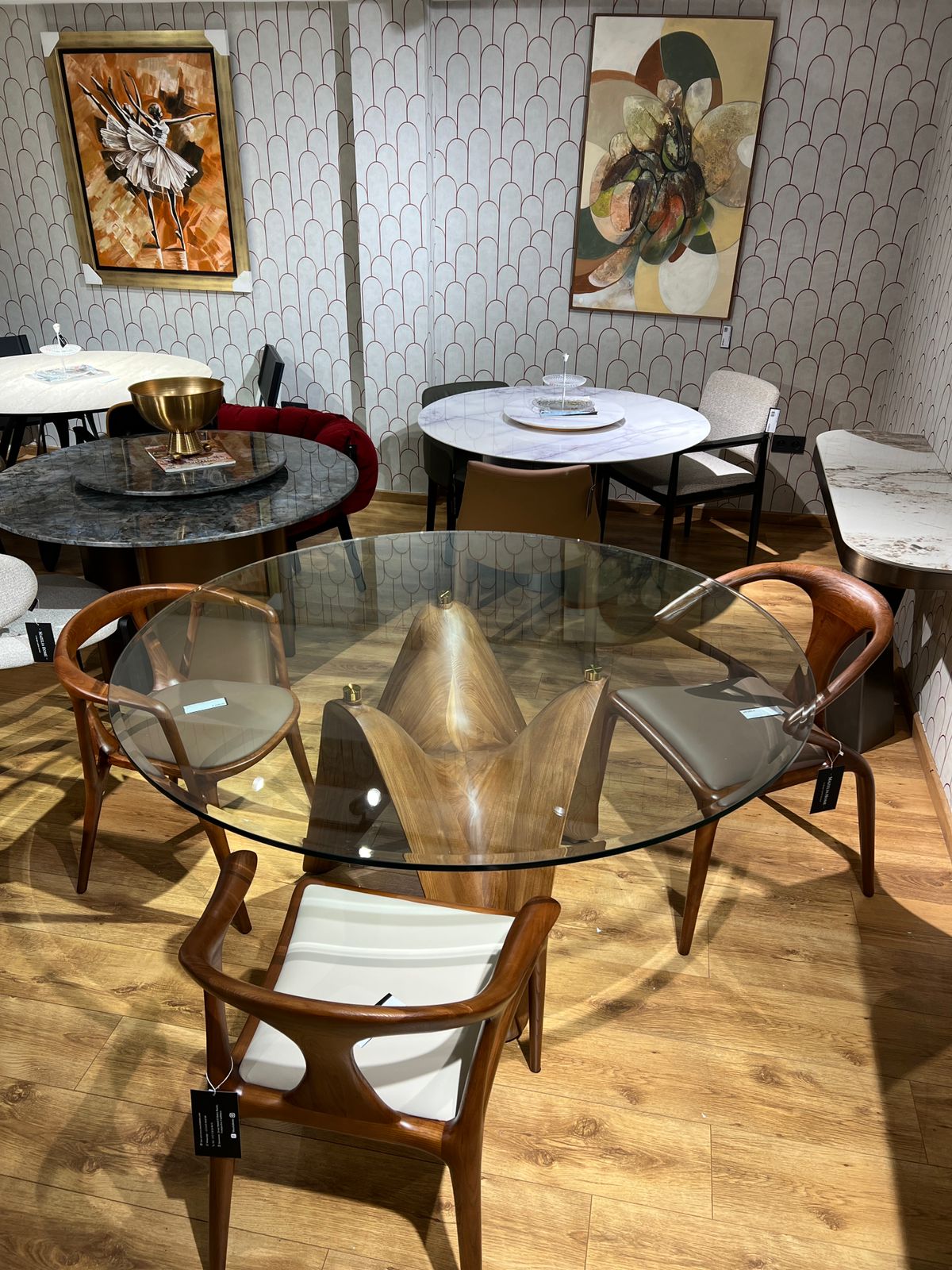 Table ronde design avec base en bois sculpté ondulé et plateau en verre