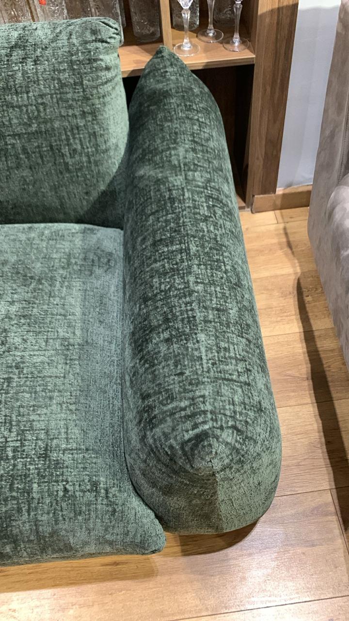 Canapé en velours chiné vert avec des accoudoirs larges et assise profonde.