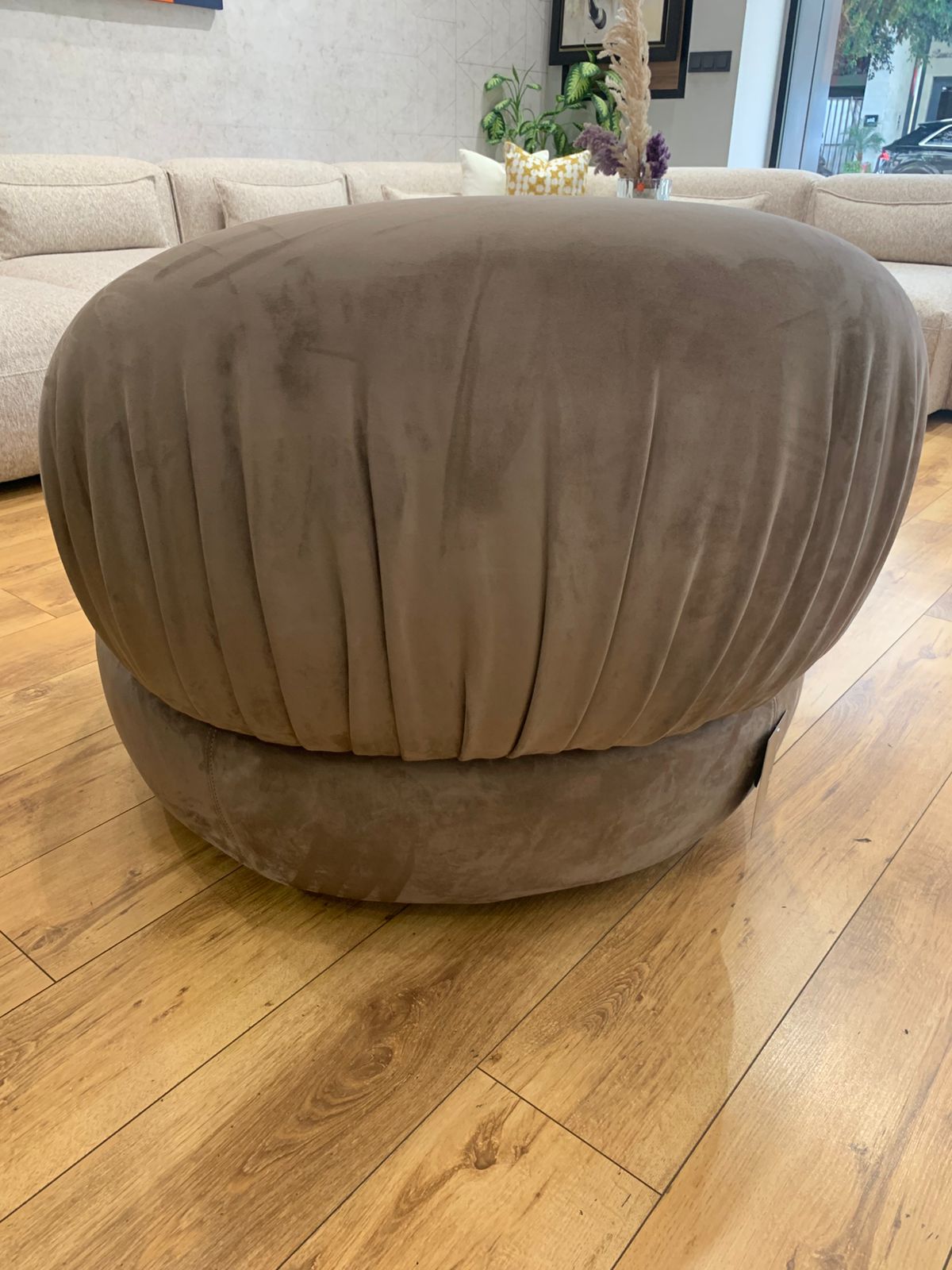 Fauteuil bergère au design arrondi en velours , avec un dossier plissé.