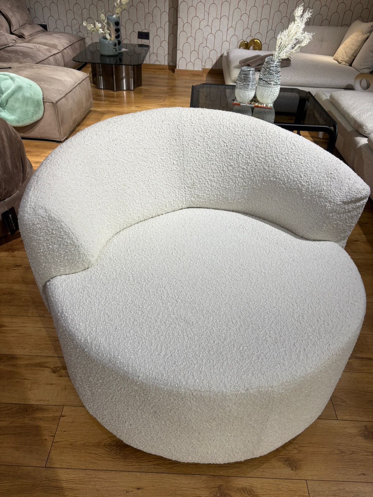 Bergère moderne blanche en tissu bouclette avec design arrondi et assise confortable pour salon contemporain.