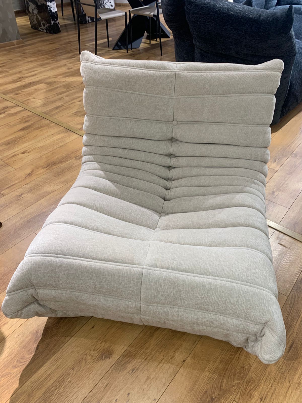  Fauteuil capitonné  avec couture plissée et assise large, style contemporain.