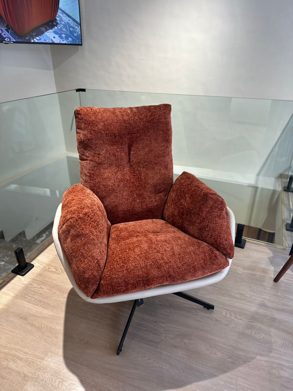 Fauteuil moderne avec dossier haut, coussins épais et base métallique stable pour un confort optimal.