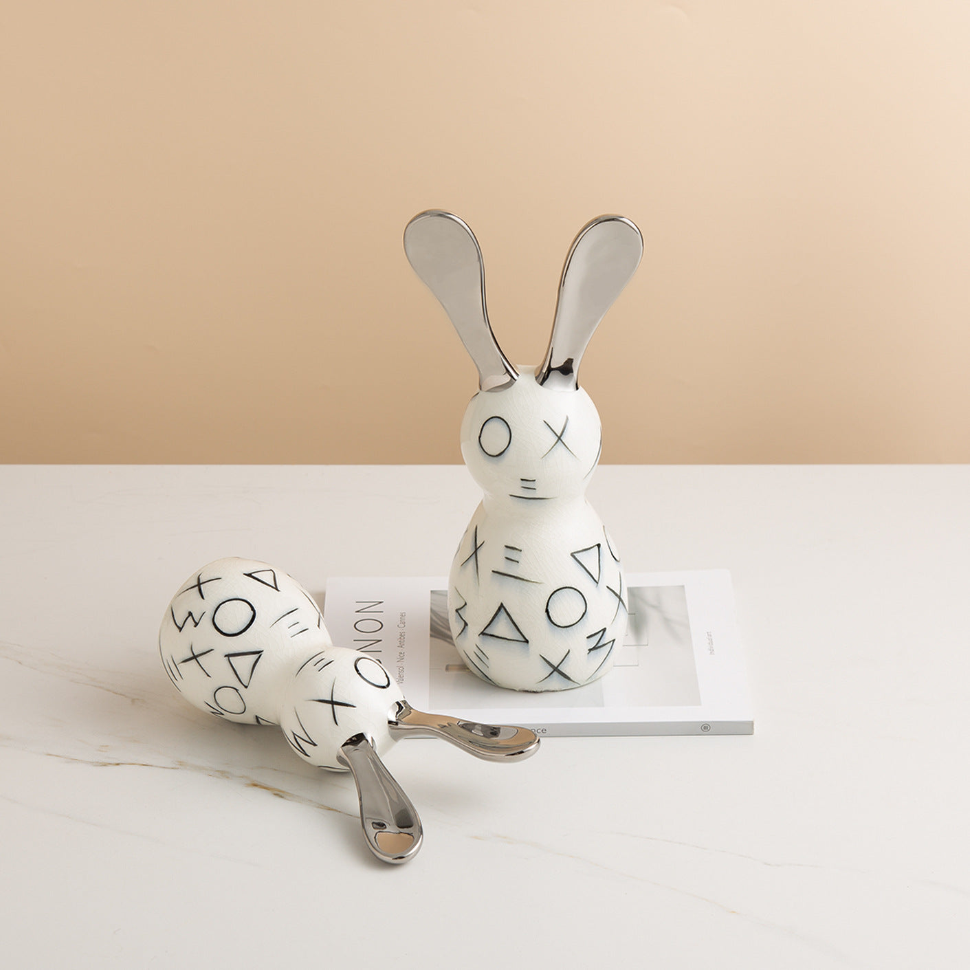 Statue décorative lapin moderne blanc et noir avec oreilles chromées pour décoration intérieure.