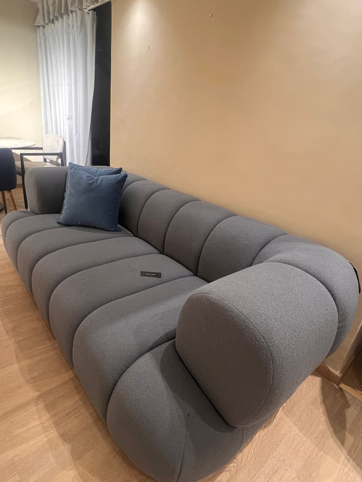 Canapé moderne avec accoudoirs arrondis, affichant un design épuré et des lignes minimalistes, idéal pour un salon contemporain.