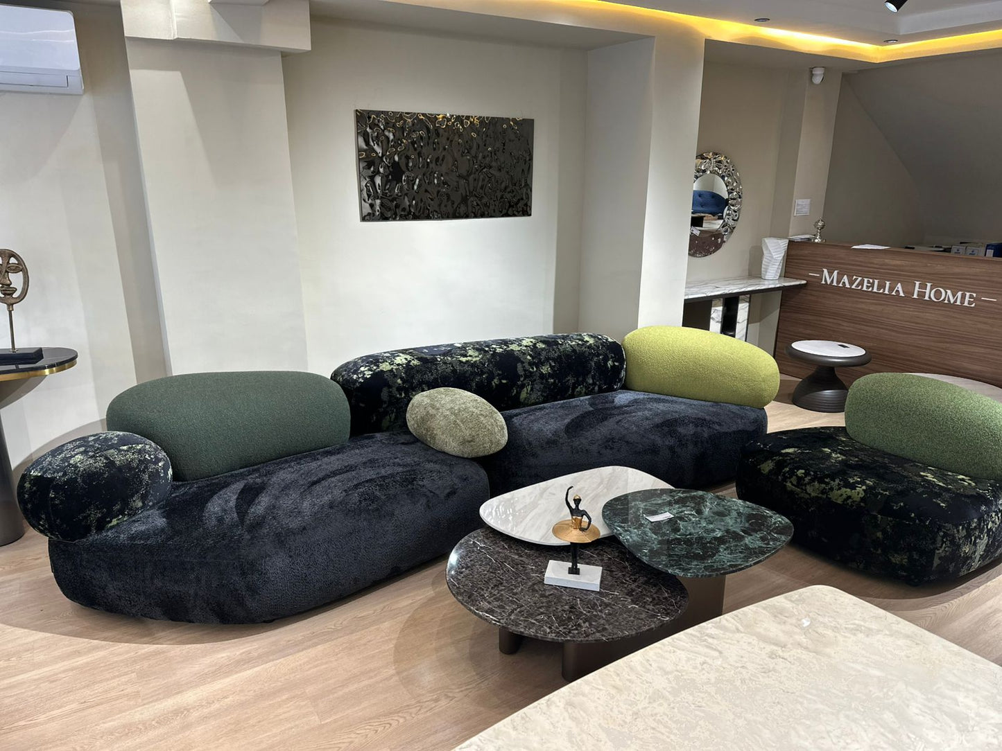 Canapé design aux formes arrondies avec dossier et coussins moelleux, inspiré d’un style contemporain et organique, placé dans un intérieur moderne.