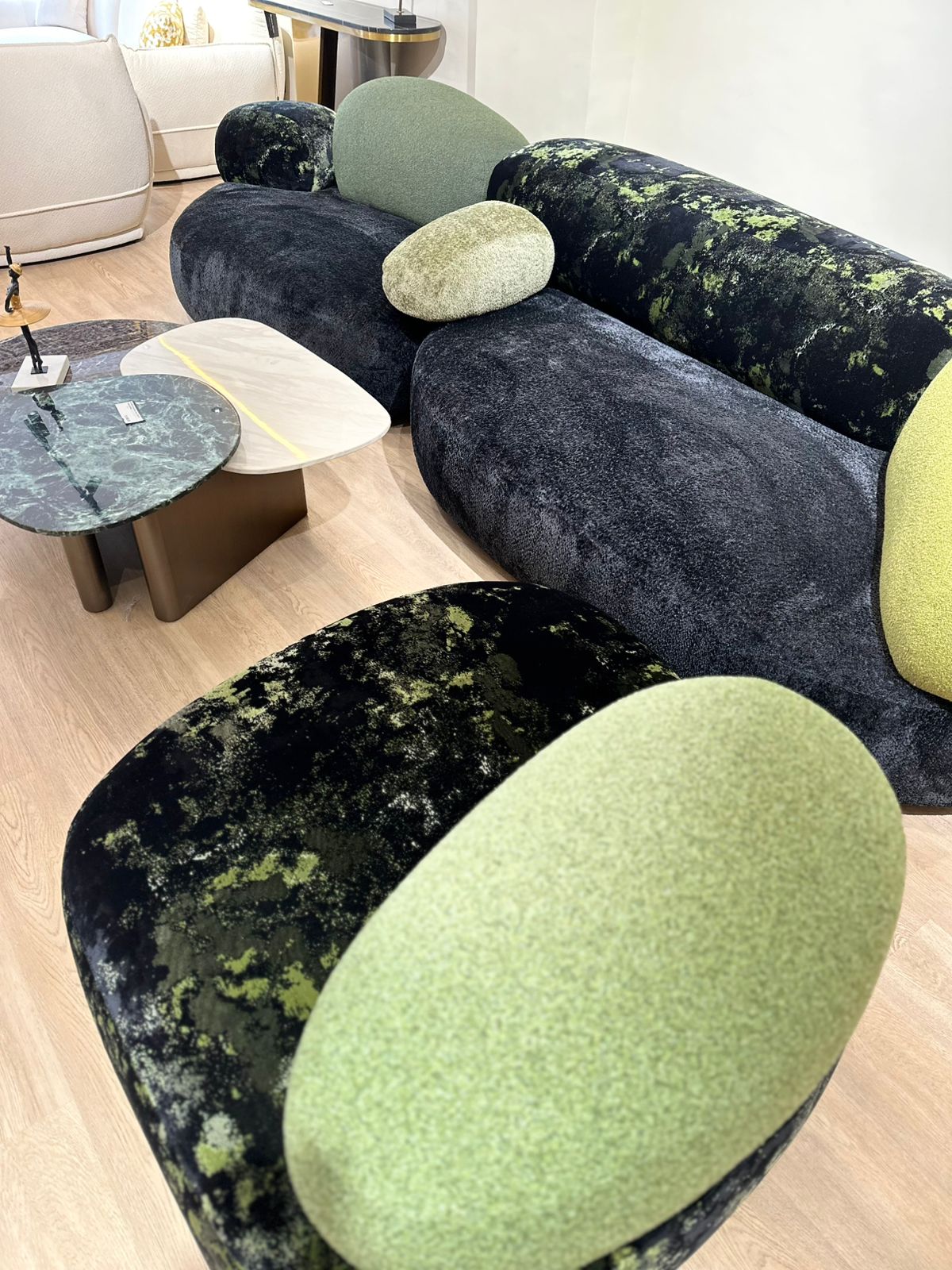 Canapé design aux formes arrondies avec dossier et coussins moelleux, inspiré d’un style contemporain et organique, placé dans un intérieur moderne.