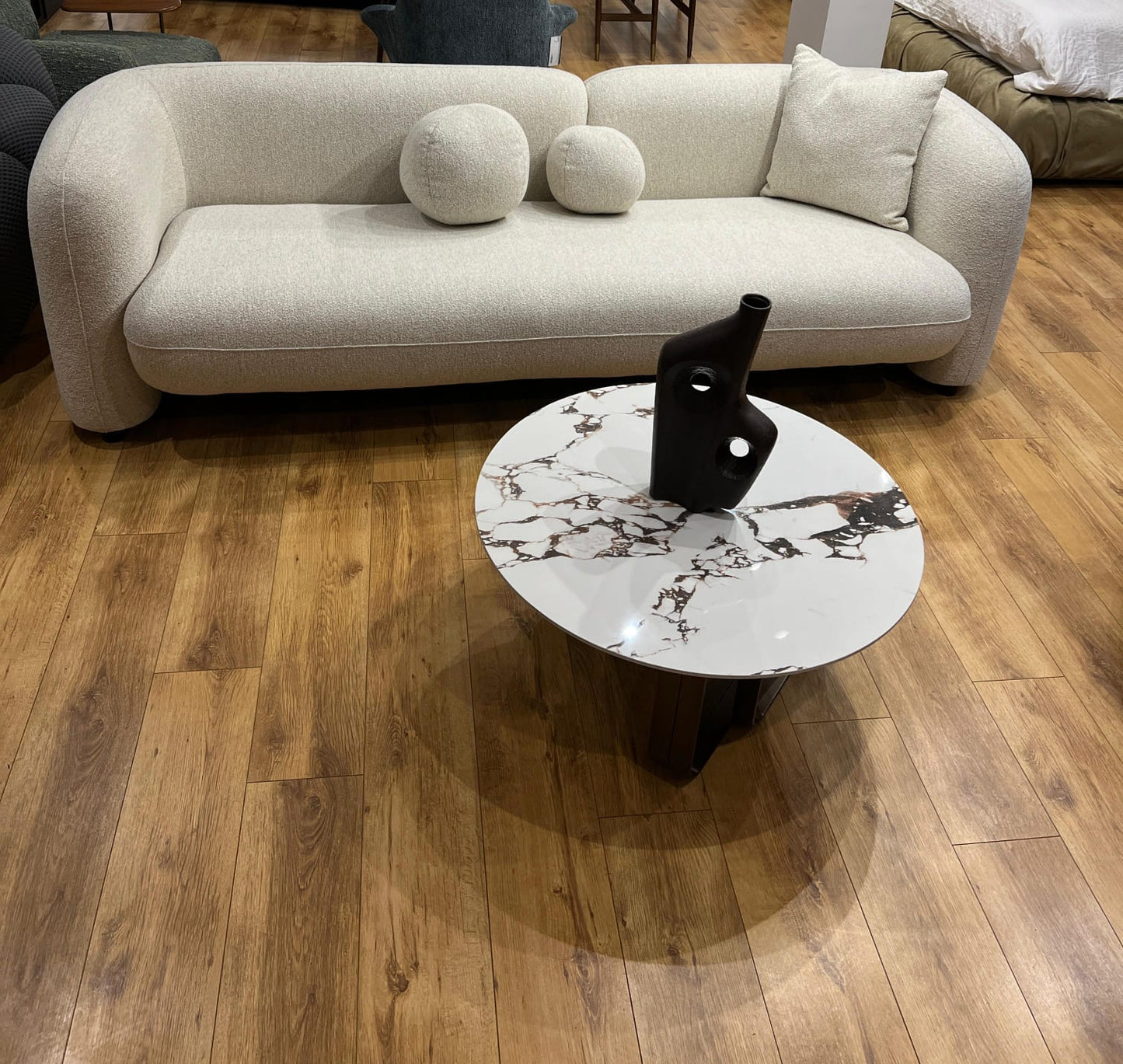 Canapé contemporain en tissu beige avec coussins décoratifs, aux lignes épurées et confortables.