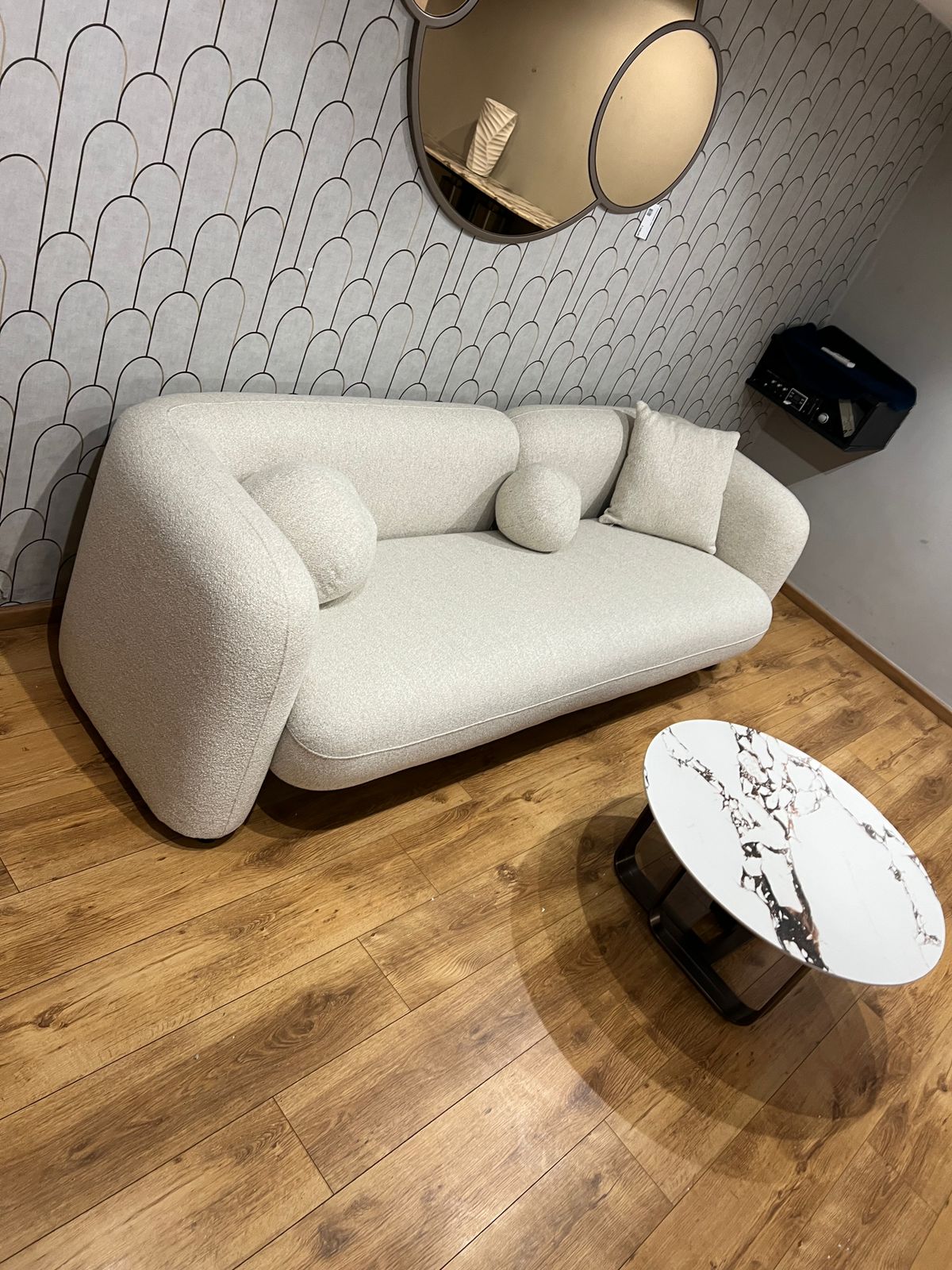 Canapé contemporain en tissu beige avec coussins décoratifs, aux lignes épurées et confortables.