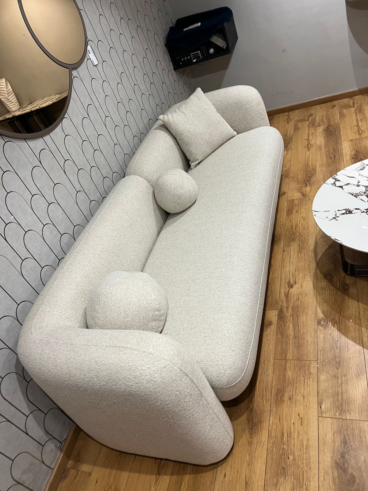 Canapé contemporain en tissu beige avec coussins décoratifs, aux lignes épurées et confortables.