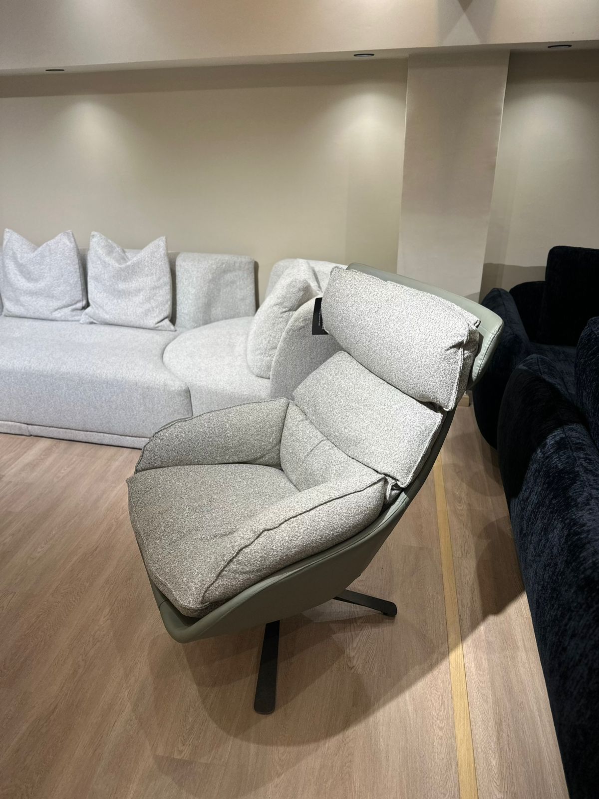 Fauteuil moderne avec dossier ergonomique, assise rembourrée et base pivotante en métal, offrant confort et style contemporain.