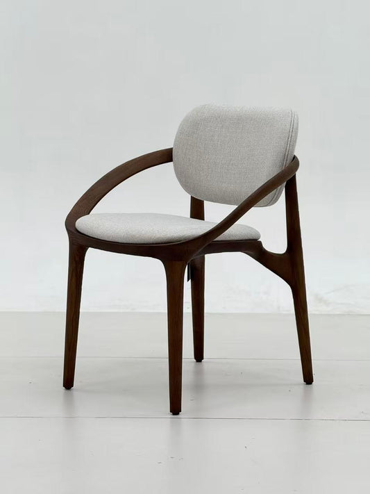 Chaise design en bois foncé avec accoudoirs, assise et dossier rembourrés en tissu clair, au style moderne et élégant.
