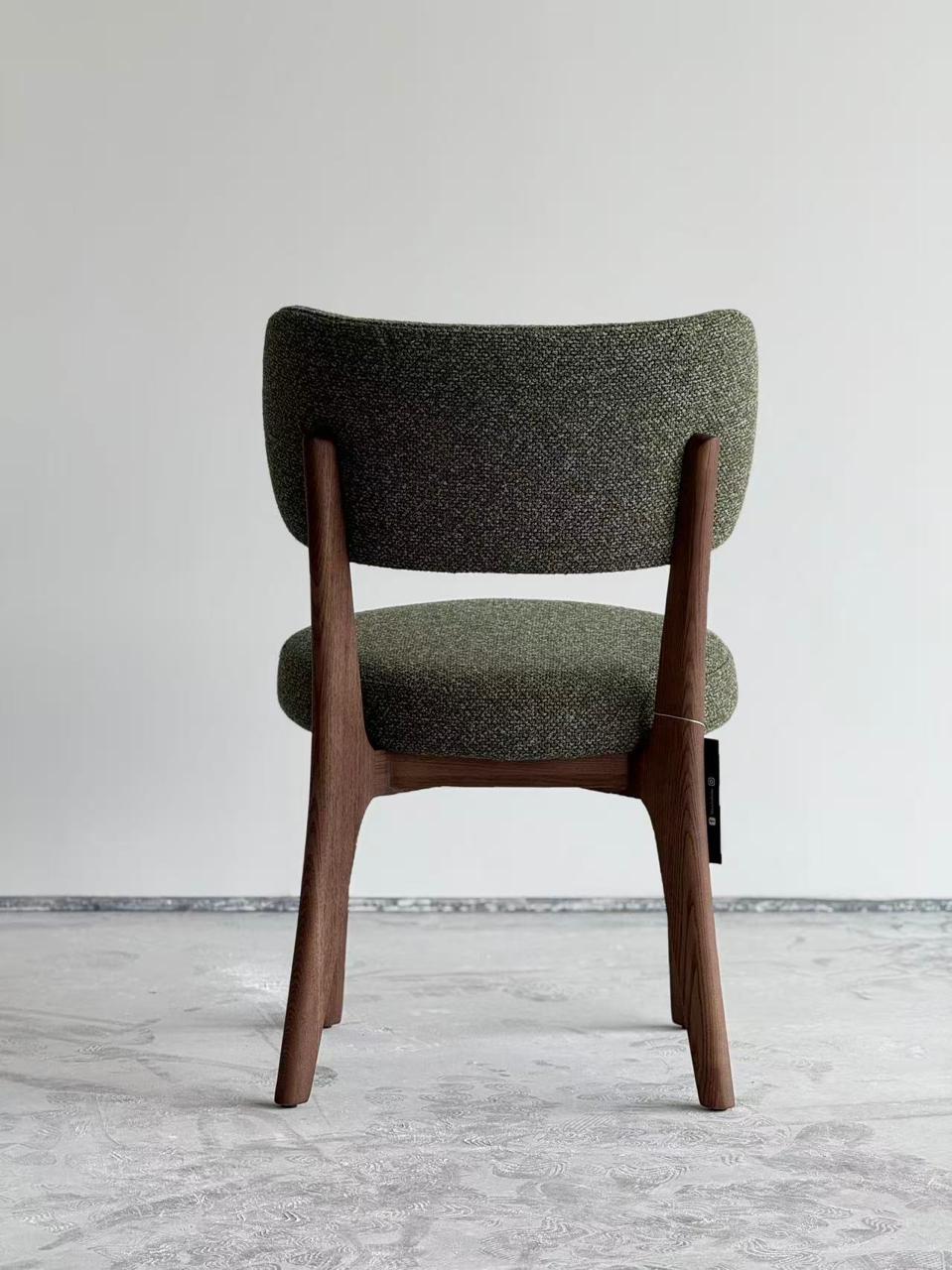  Chaise design en bois foncé avec assise et dossier rembourrés en tissu vert, style moderne et élégant .