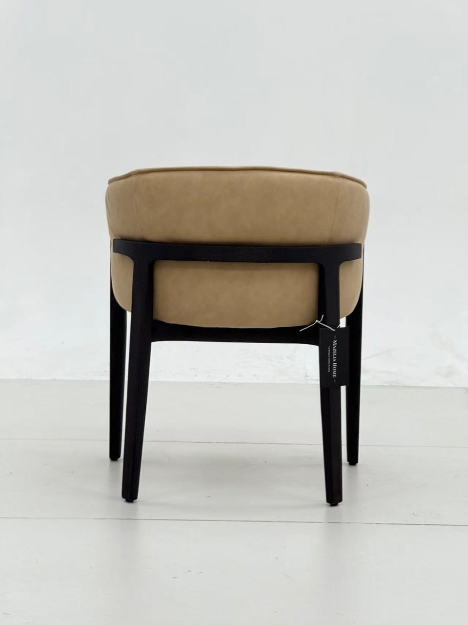 Chaise design rembourrée en tissu beige avec dossier enveloppant et structure en bois foncé, au style moderne et élégant.