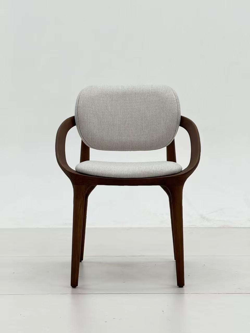 Chaise design en bois foncé avec accoudoirs, assise et dossier rembourrés en tissu clair, au style moderne et élégant.