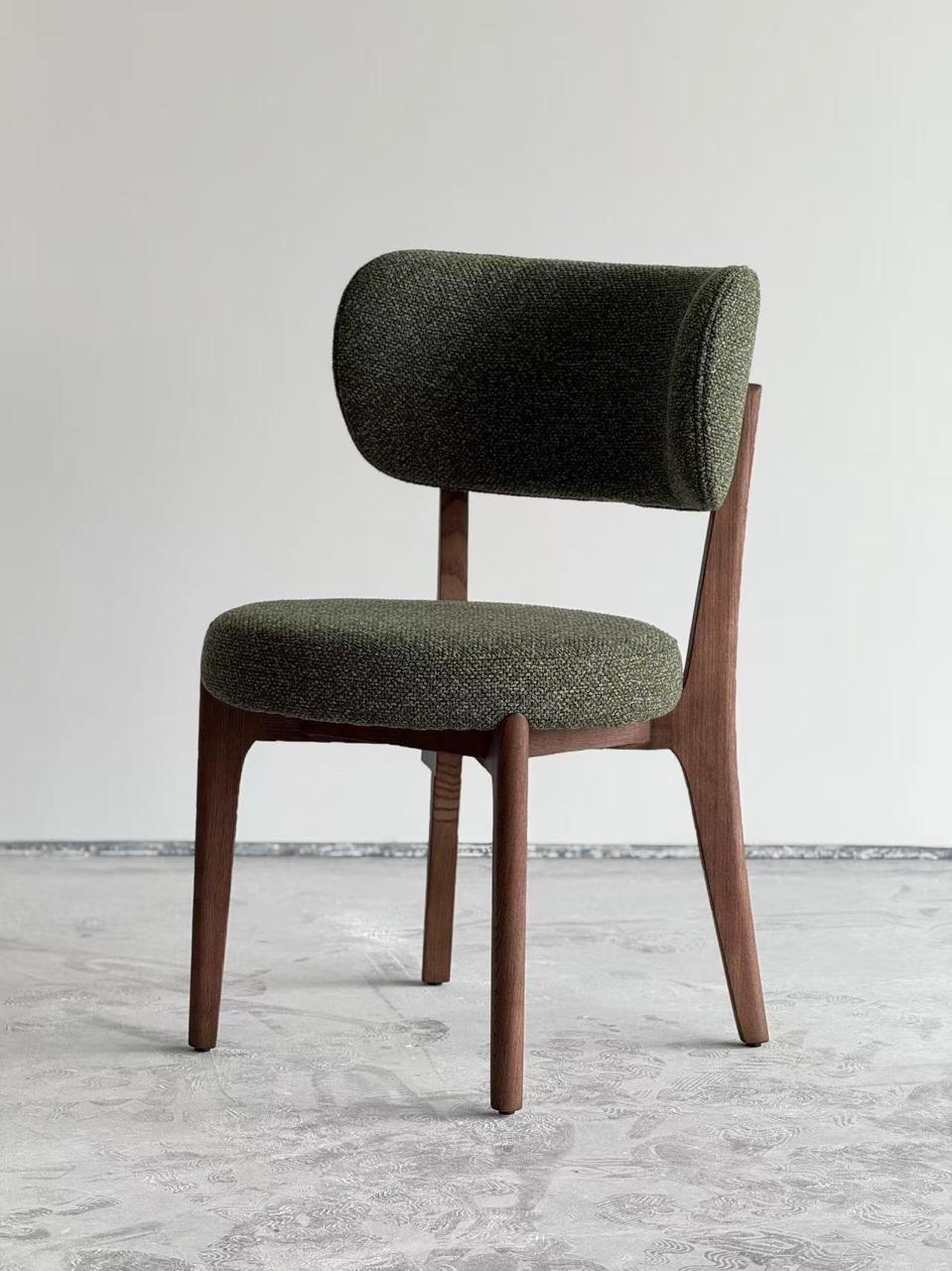  Chaise design en bois foncé avec assise et dossier rembourrés en tissu vert, style moderne et élégant .
