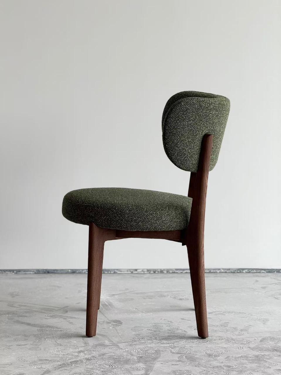  Chaise design en bois foncé avec assise et dossier rembourrés en tissu vert, style moderne et élégant .