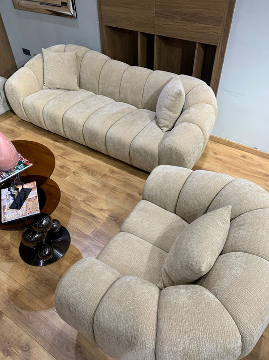 Salon élégant avec canapé trois places et fauteuil aux formes douces et arrondies