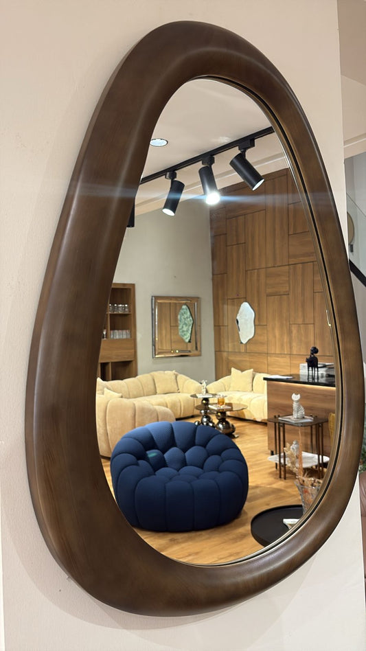 Miroir mural design forme organique avec cadre en bois marron épais dans un intérieur moderne