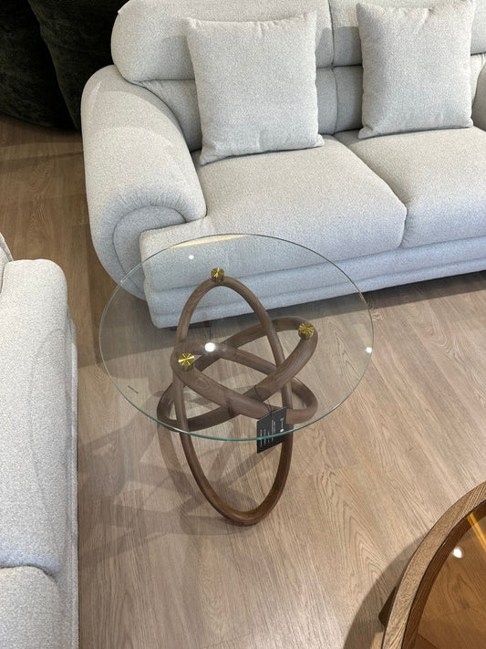 Table d’appoint ronde en verre et bois sculpté, au design moderne avec touches dorées. Élégante, légère et idéale pour un salon contemporain.
