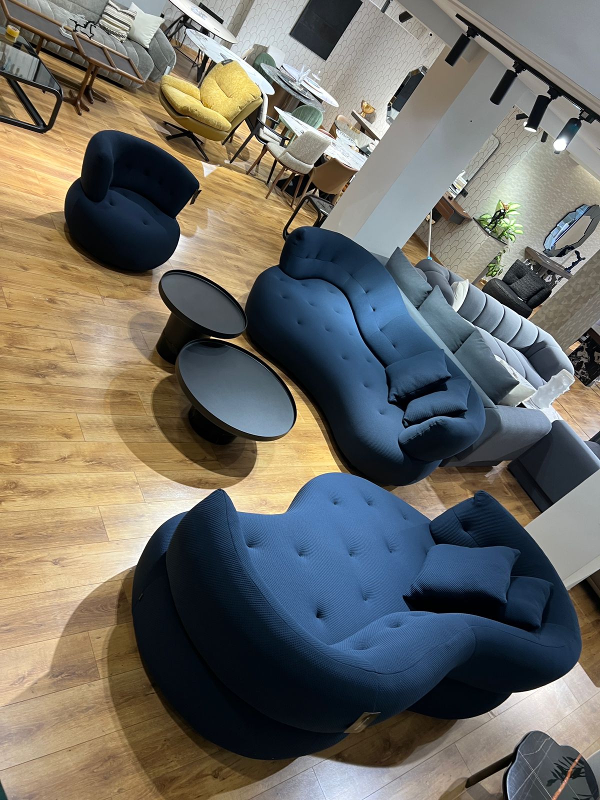Salon design avec canapé aux courbes modernes et fauteuils assortis.