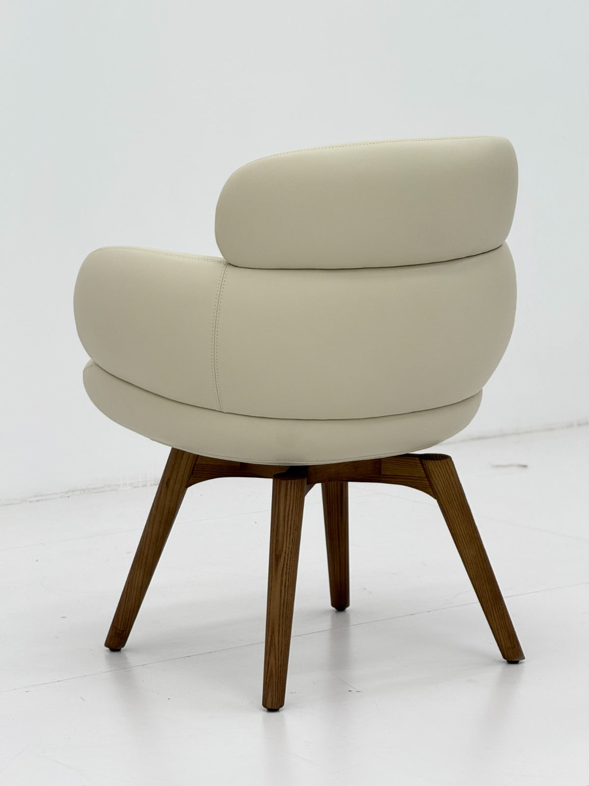 Chaise design en vrai cuir crème avec accoudoirs rembourrés et pieds en bois massif, idéale pour une salle à manger ou un bureau contemporain