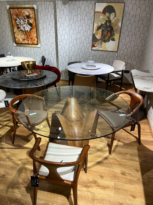 Table ronde design avec base en bois sculpté ondulé et plateau en verre