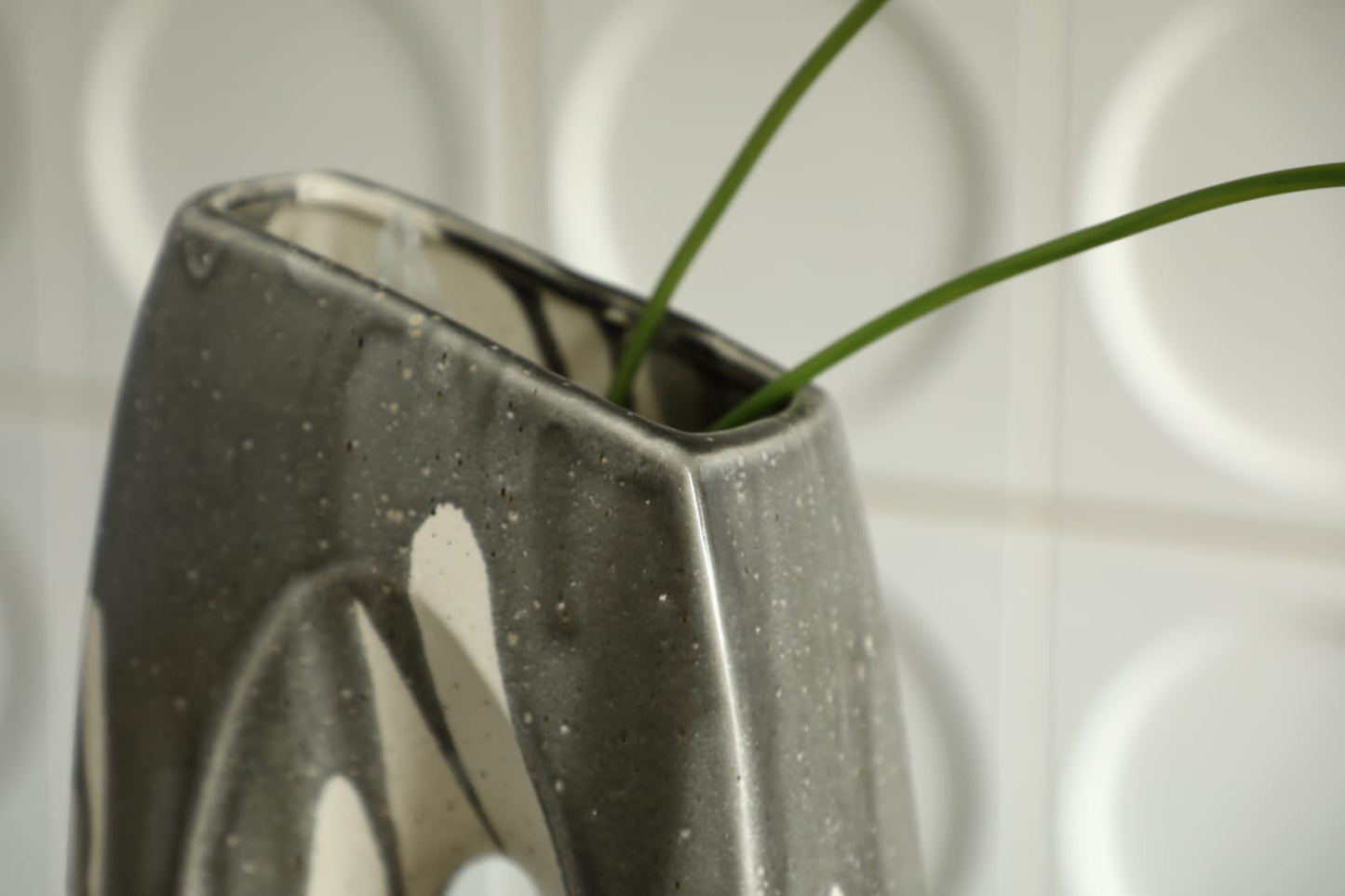Vase décoratif moderne en céramique noir et ivoire avec design sculptural ajouré.