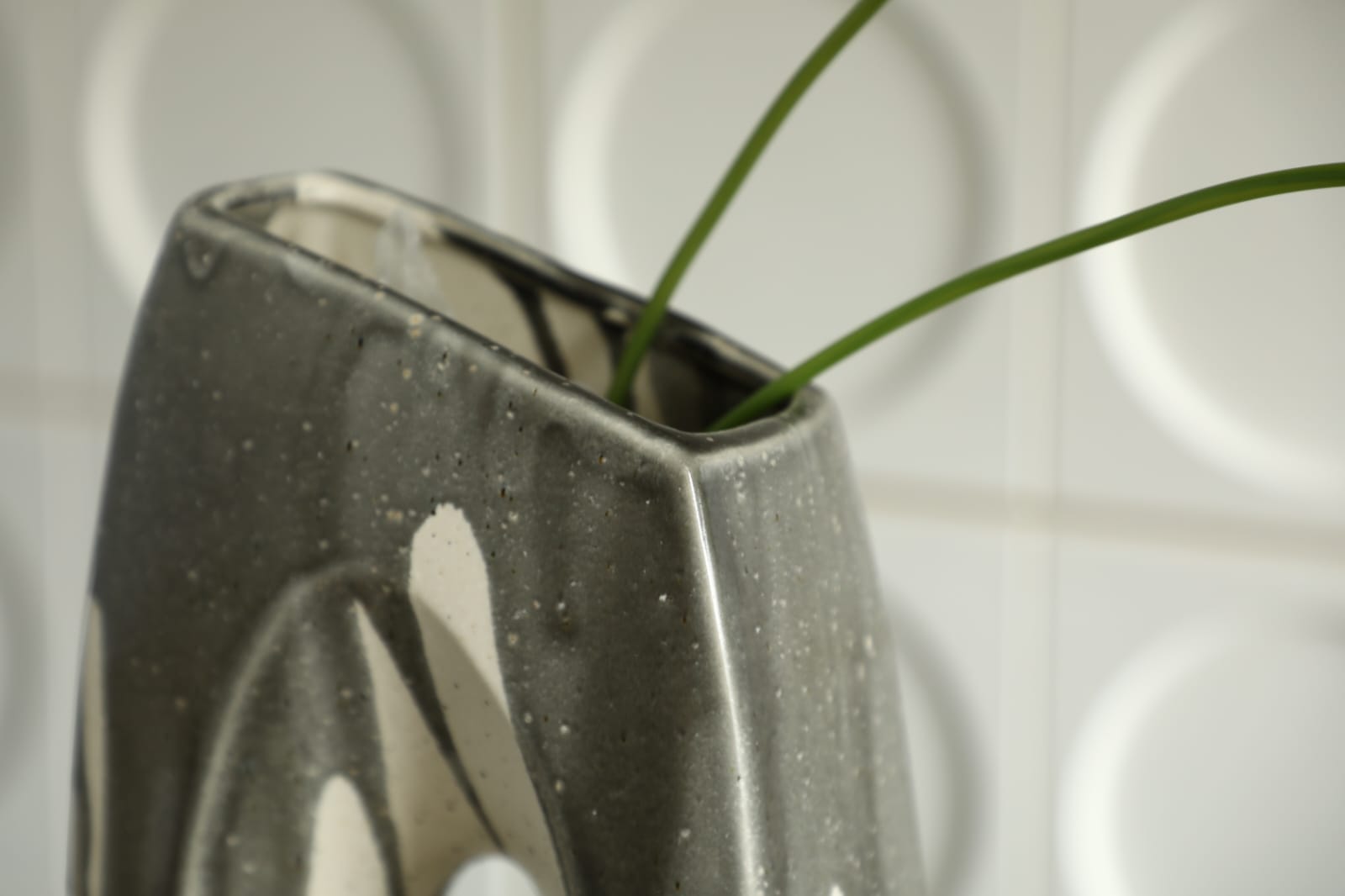 Vase décoratif moderne en céramique noir et ivoire avec design sculptural ajouré.