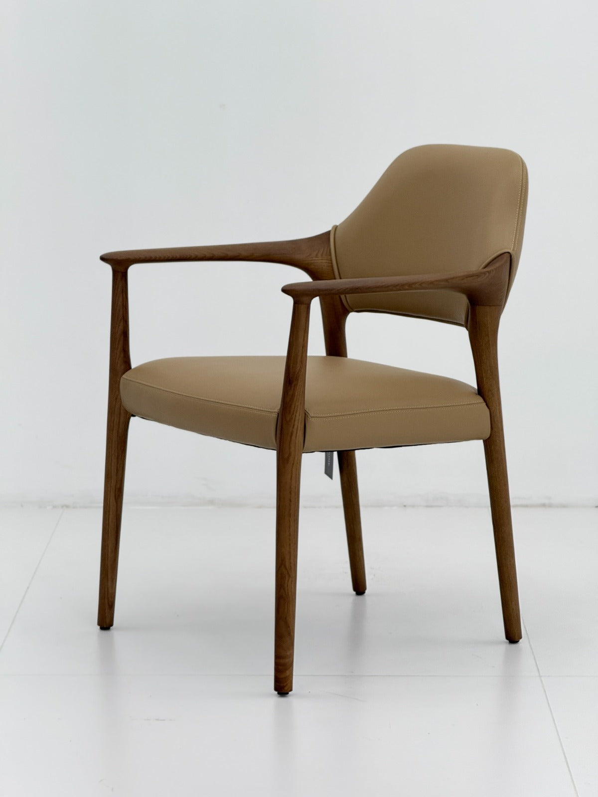 Chaise design avec structure en bois, accoudoirs élégants, assise et dossier rembourrés, idéale pour une salle à manger ou un espace professionnel