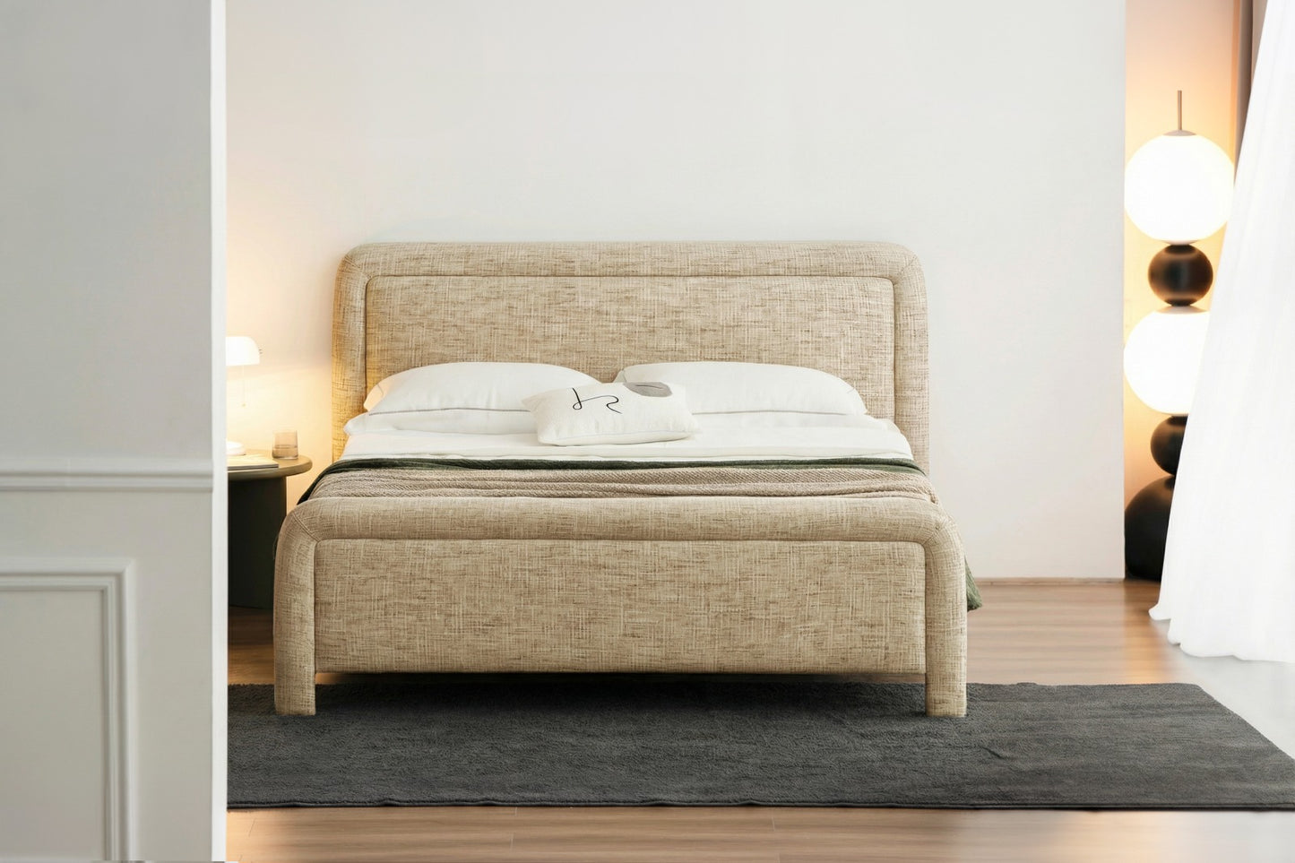Tête de lit rembourrée au design moderne et arrondi, idéale pour une chambre élégante et chaleureuse.