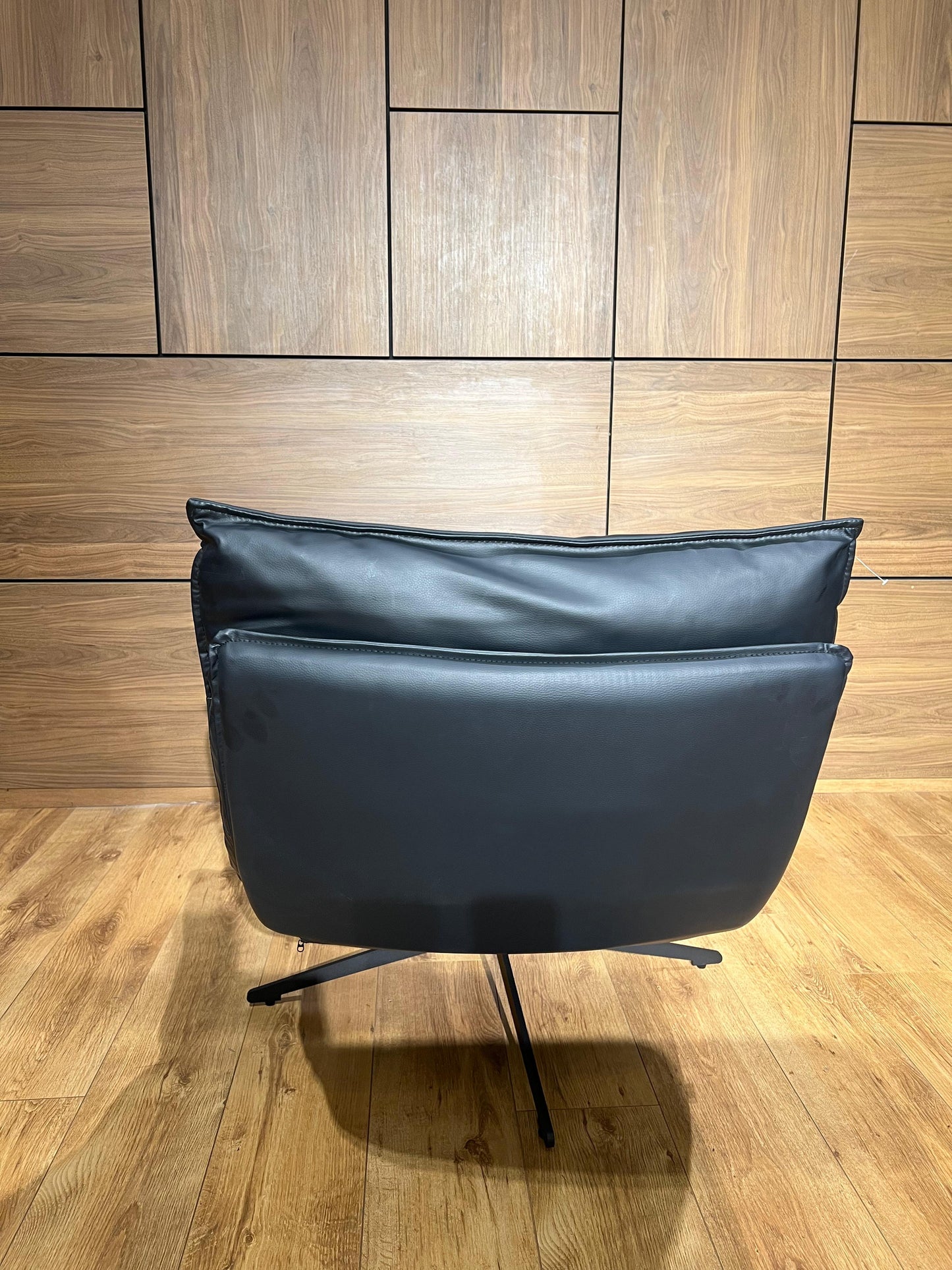 Bergère moderne noire en similicuir avec structure métallique élégante pour salon contemporain.