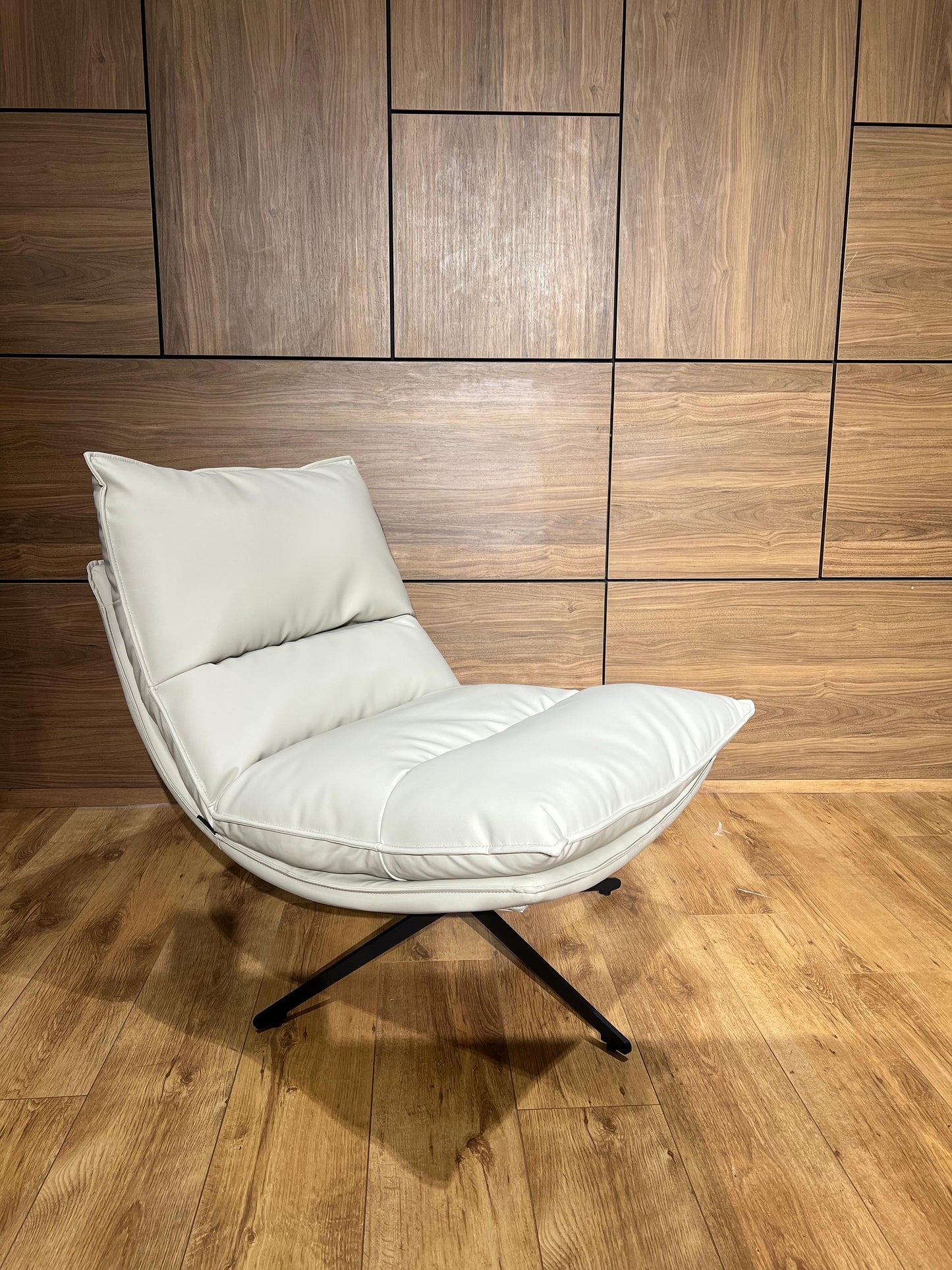 Bergère moderne en similicuir avec structure métallique élégante pour salon contemporain.